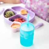 Childs meal on a divided purple plate and Bumkins Silicone Straw Cup with Lid: Blue, perfect for independent drinking skills.