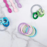 Bumkins Silicone Teething Rings 4 Pack: Spring in pastel blue, pink, and green soothe gums with food-safe silicone on marble.