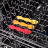 Three Bumkins Tutti-Frutti silicone dipping spoons in red, orange, and yellow sit neatly on a dishwasher rack.