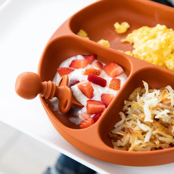 Clay silicone divided plate with eggs, yogurt, and hash browns, plus a Bumkins Silicone Chewtensils® baby spoon for BLW.