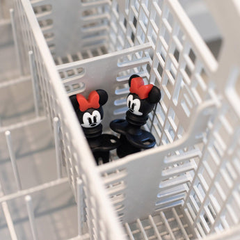 Two Minnie Mouse Silicone Chewtensils® by Bumkins rest in the cutlery basket, ready for babys weaning adventures.