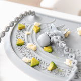 Gray Bumkins Silicone Chewtensils® placemat with sensory bumps, chain, fork, and food bits for baby-led weaning.