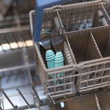 Bumkins Spoon + Fork: Blue sit in the dishwashers utensil rack with toddler utensils, ready for a wash cycle.