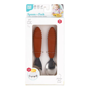 Bumkins Spoon + Fork: Clay toddler set with orange handles in a playful child-themed white box, ideal for self-feeding.