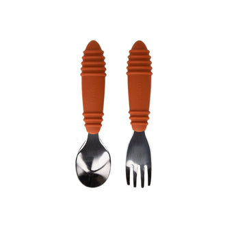 The Bumkins Spoon + Fork: Clay features orange ribbed handles and is shown side by side on a white background.