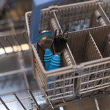 The Bumkins Spoon + Fork in Dark Blue and childrens utensils are in the cutlery basket of an open dishwasher.