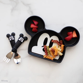 Kids meal with rotini and strawberries on Mickey Mouse plate, paired with Bumkins Spoon + Fork: Mickey Mouse, all on marble.