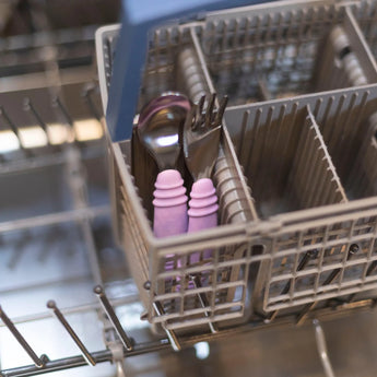 Bumkins Spoon + Fork: Lavender set sits in the dishwasher utensil basket.