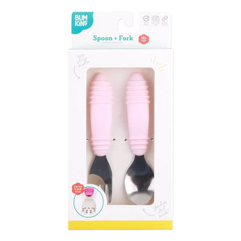 The Bumkins Spoon + Fork: Pink set comes with ergonomic silicone utensils for self-feeding, all neatly displayed in a clear box.