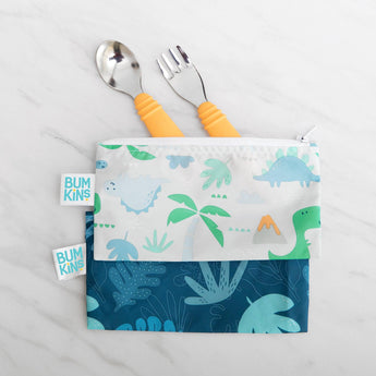 Bumkins Spoon + Fork: Tangerine and dinosaur-themed pouch on a marble surface make mealtime fun for toddlers.