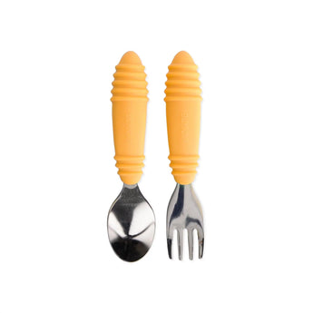 Bumkins Spoon + Fork: Tangerine set has yellow handles & stainless steel heads, ideal for toddler self-feeding on a white background.