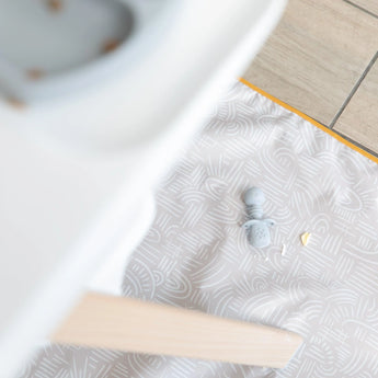 The Bumkins Splat Mat: Wander is waterproof, machine washable, holds toys and crumbs by a high chair on tiled floors.