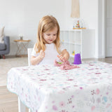 Blonde girl plays with pink kinetic sand on a Bumkins Floral Splat Mat in a bright room for easy cleaning.