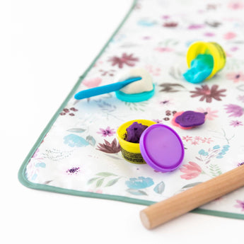 Use Bumkins Splat Mat: Floral to easily clean up play dough with tools on its colorful, waterproof surface.