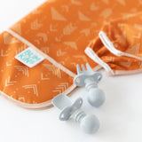 Orange Bumkins Sleeved Bib: Grounded, Desert Boho collection, with geometric patterns. Comes with gray fork and spoon for weaning.