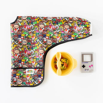 Sleeved Bib: Super Mario™ Mashup by Bumkins, yellow bowl with spoon, and retro handheld console on white background.