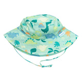 The Bumkins Sun Hat: Green Dinosaurs features a white base with colorful dino patterns, breathable fabric, and an adjustable chin strap.