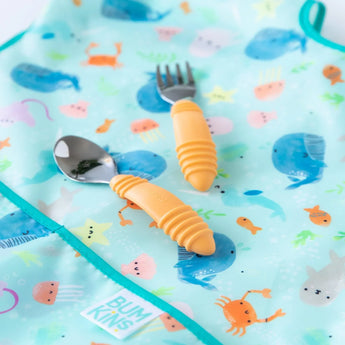 Bumkins Junior Bib: Ocean Life with adjustable fit, sea creatures on waterproof fabric, includes yellow spoon and fork.