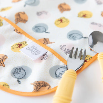 Bumkins Junior Bib: Winnie and Friends, with yellow trim, comes with a matching fork and spoon to add fun to mealtime.