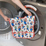 A person puts a Bumkins Junior Bib: Super Mario™ & Luigi into a front-load washing machine.