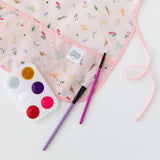 Bumkins Princess Magic smock is colorful, waterproof, and easy to clean, perfect for painting with palette and paintbrushes.