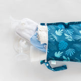 The Bumkins Wet Bag: Blue Tropic is waterproof, ideal for baby essentials like clothes and bottles, shown partially open on white.