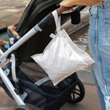 A person pushes a stroller with a Bumkins Wet Bag: Wander hanging from the handle.