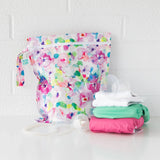 Bumkins Wet Bag: Watercolor with breast pump parts & baby cloth diapers in white, teal, pink on white brick. Great reusable wet bags.