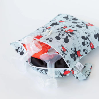 A partially open Bumkins Wet Bag: Mickey Mouse Classic, waterproof, holds baby bottle parts and a small red item.