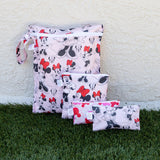 Three Bumkins Minnie Mouse Classic travel organizers on grass, leaning against a beige wall.