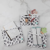 The Clear Travel Bag 3-Pack: Hearts by Bumkins holds notebooks, lipstick, scrunchies, socks, and a green clip.