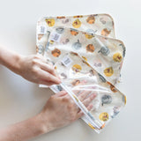 Hands opening a TSA-compliant Bumkins travel bag with playful Winnie & Friends designs from the Clear Travel Bag 3-Pack.