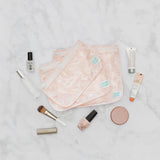 Makeup items with Bumkins Clear Travel Bag 3-Pack: Lace (pink floral) on a marble surface, ideal for TSA-compliant travel.